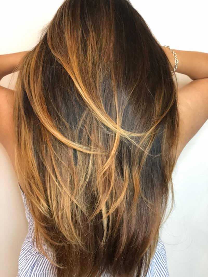 Long, wavy hair with honey and caramel highlights, styled down and loose.